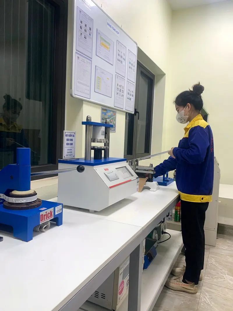 Nhân viên QC đo độ nén vòng, nén cạnh tại phòng thí nghiệm